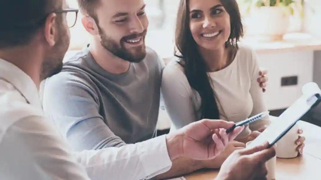 A group of people, smiling and looking at a pad of paper with notes on it.